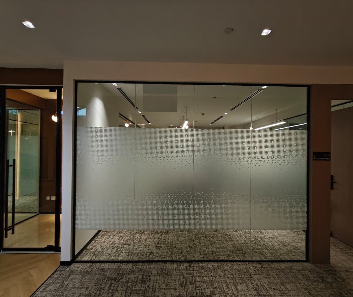 Full-height glass partition with frosted privacy film in an Emaar Square office, Dubai