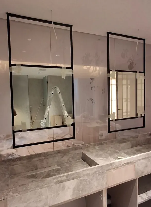Glass and mirror panels being installed above a stone vanity at Marina Residences, Dubai