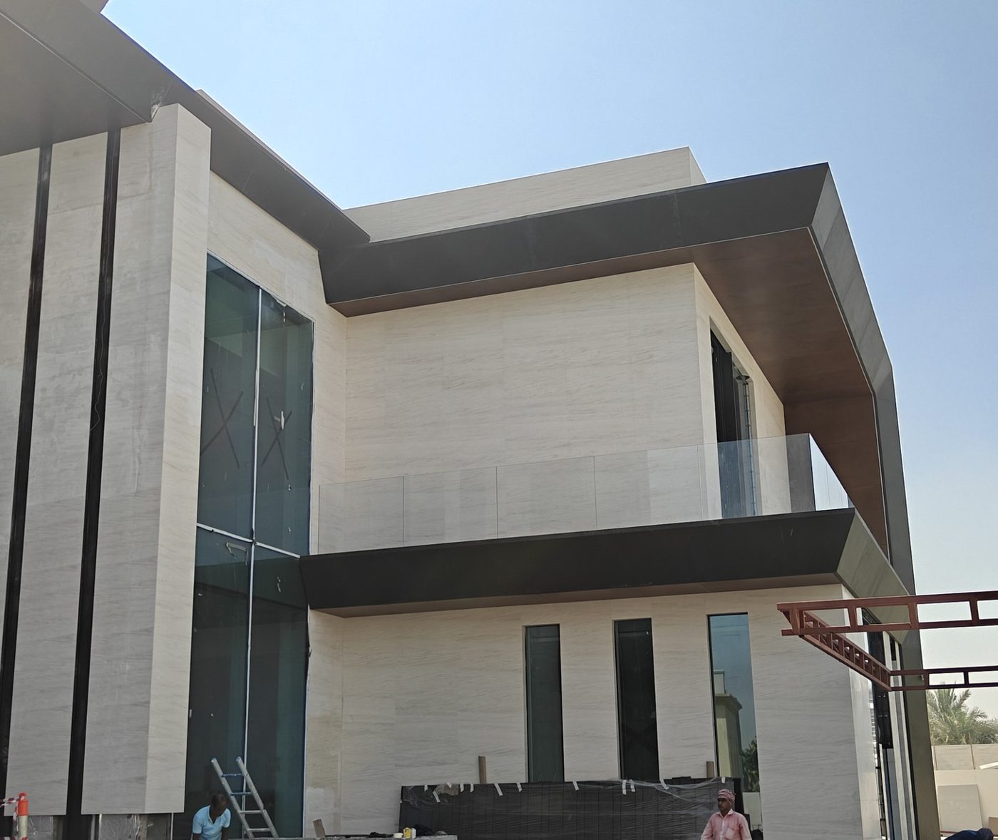 Large glazed openings and external glass balustrade on a contemporary stone villa in Dubai Hills
