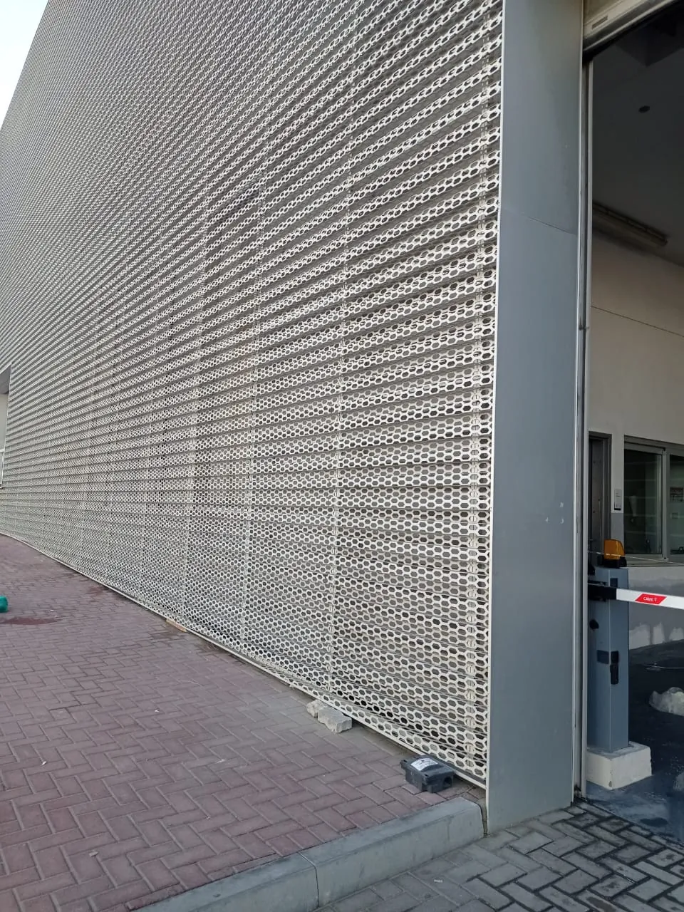 Audi showroom perforated façade cladding after rectification, continuous pattern beside the entrance