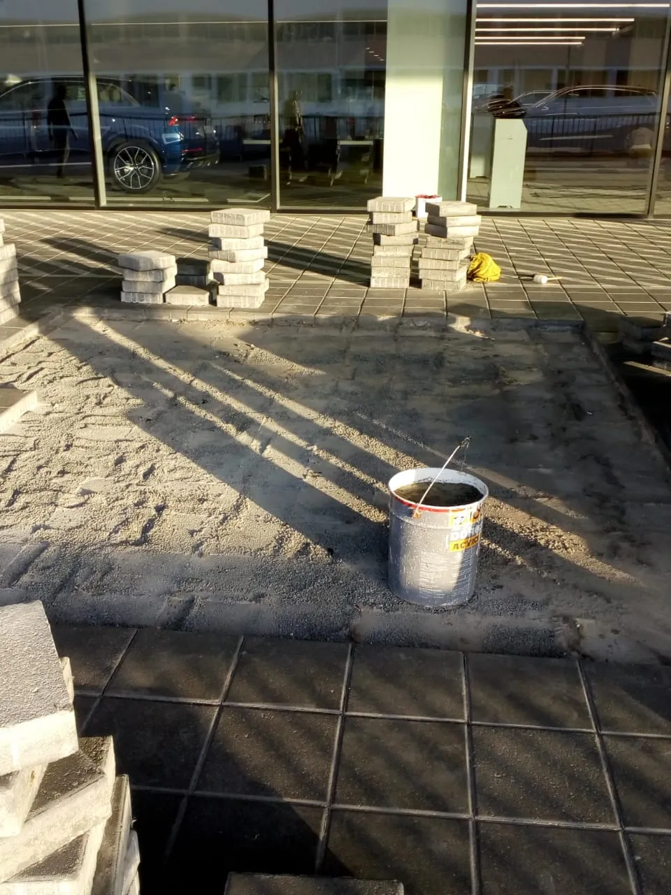 Audi service centre main entrance interlock paving during rectification, blocks stacked on bedding sand