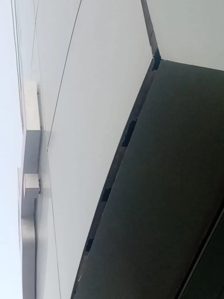 Porsche showroom cladding before rectification, distorted panels at the canopy return